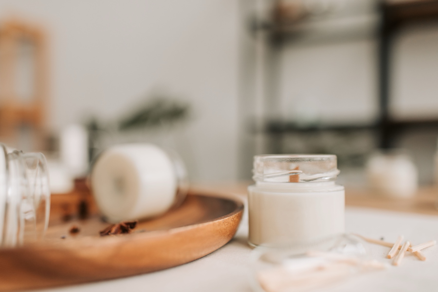 Bougie en cire de soja allumée dans un salon cocooning, ambiance chaleureuse