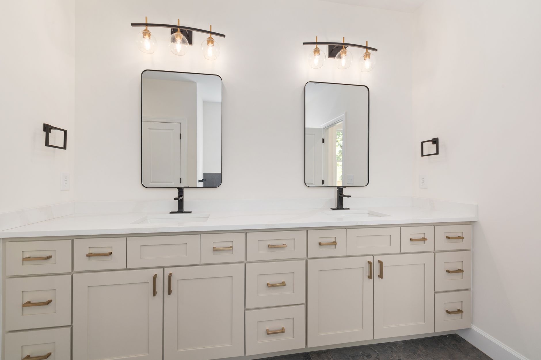 double vasque blanche surmontée de deux miroirs, chacun éclairé par une applique à trois globes en verre