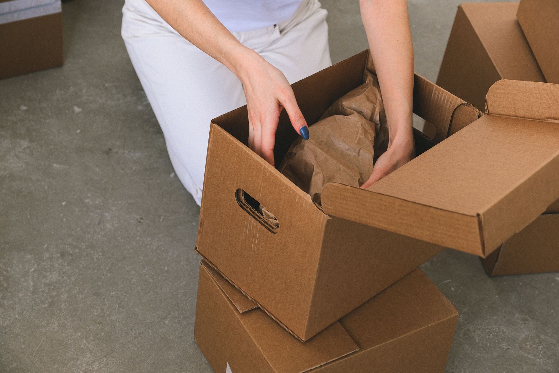 personne qui trie ses affaires et les emballe dans un carton avant de vider un logement